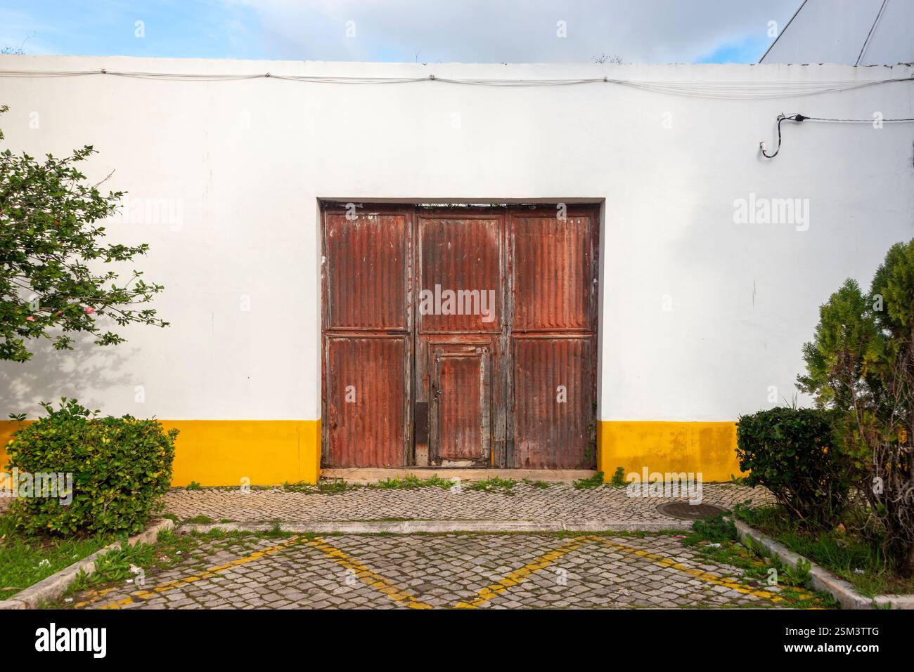 esterno di un edificio con una porta in ferro ondulato arrugginito Foto Stock