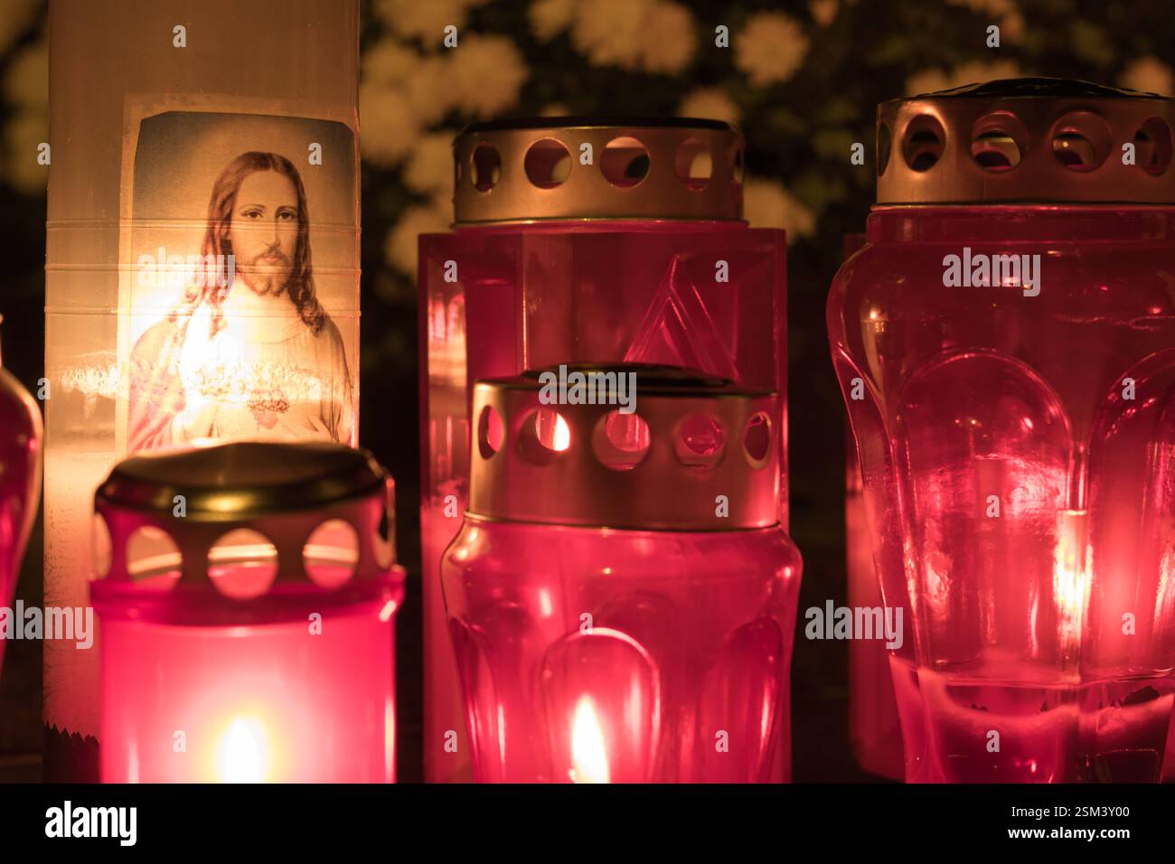 Candele rosse illuminate e un'immagine in un'atmosfera serena, perfetta per momenti di riflessione spirituale e di preghiera in un ambiente tranquillo e significativo Foto Stock