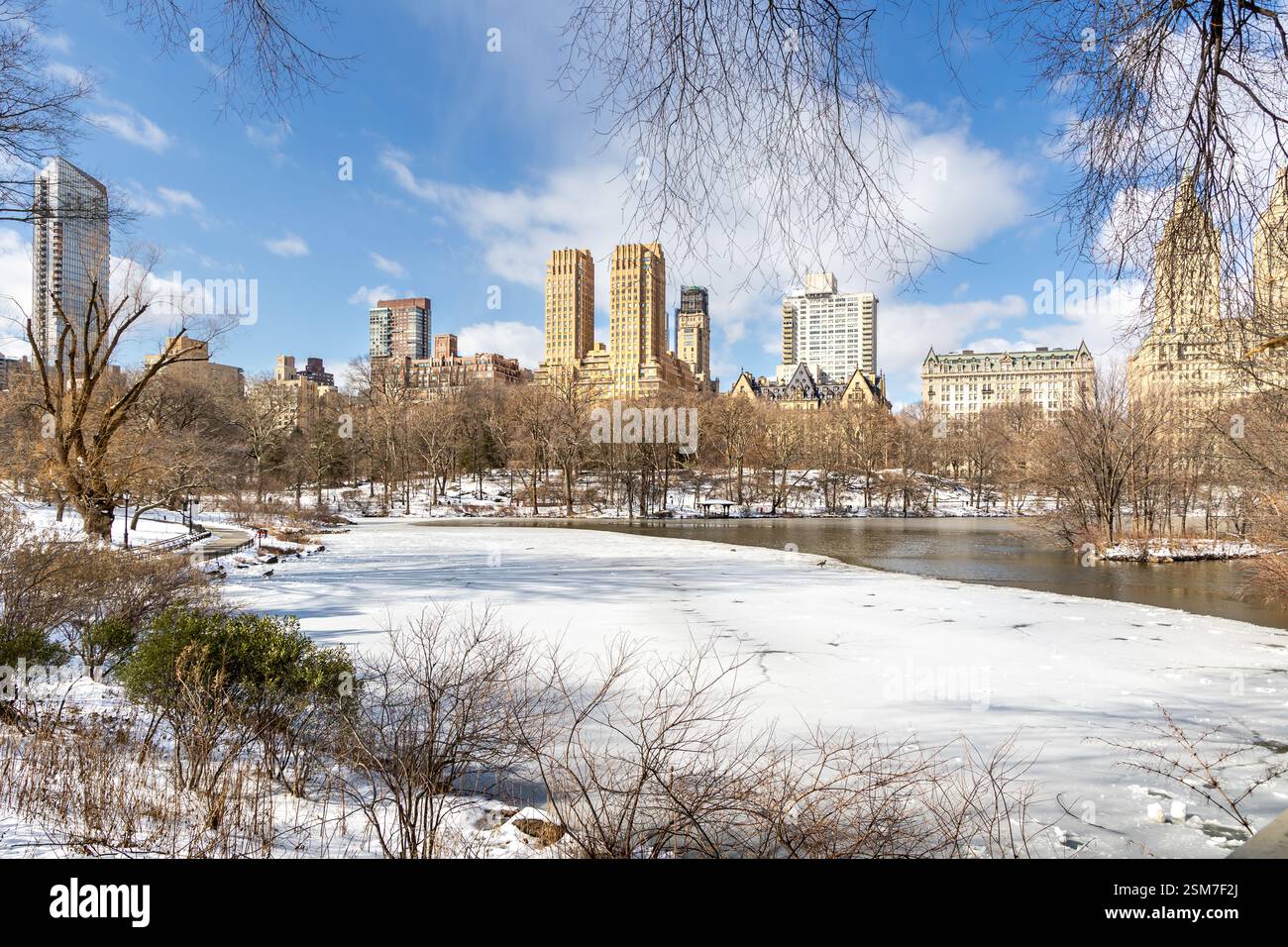 I visitatori apprezzeranno il tranquillo paesaggio invernale di Central Park, con un lago ghiacciato e innevato nel febbraio 2025. Foto Stock