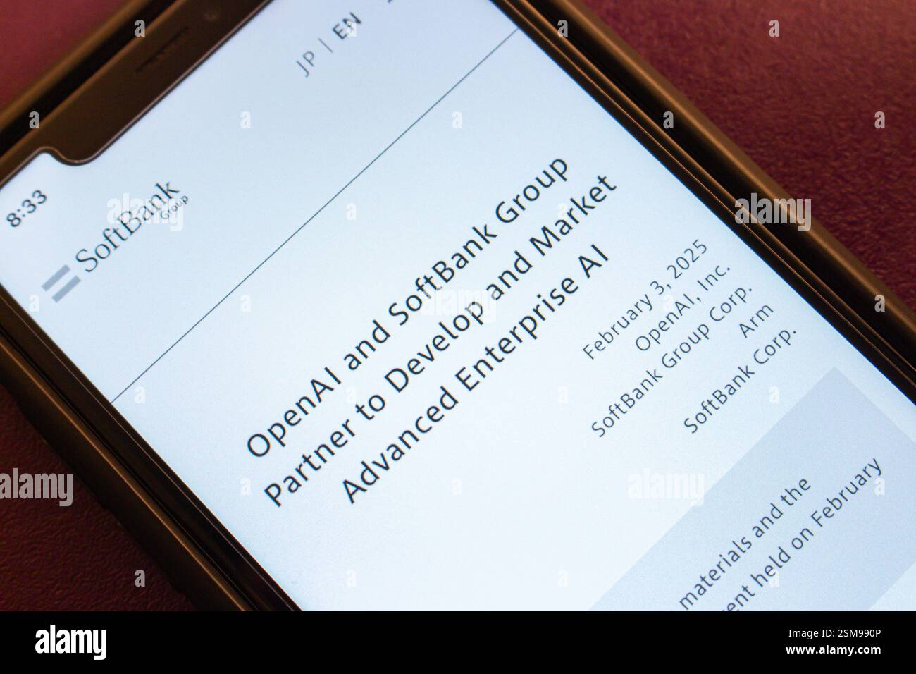 Primo piano dello schermo di uno smartphone che mostra un articolo sulla partnership tra SoftBank Group e OpenAI per lo sviluppo dell'intelligenza artificiale aziendale. Foto Stock