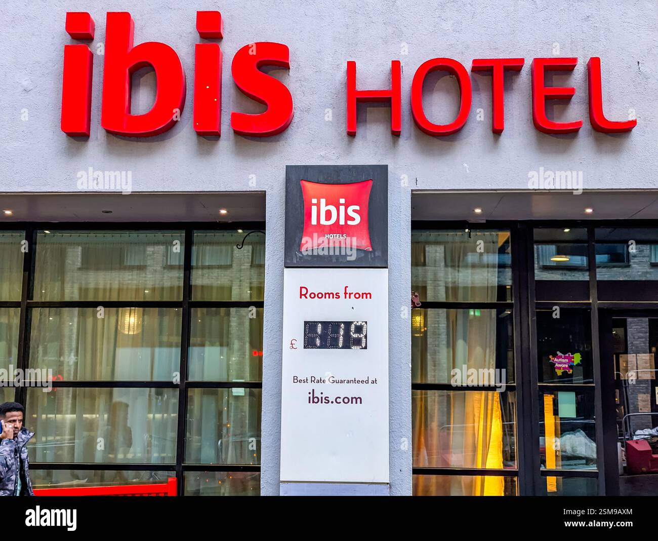 Primo piano del logo dell'hotel ibis in rosso e un cartello indicante le camere disponibili - Immagine stock catturata con smartphone