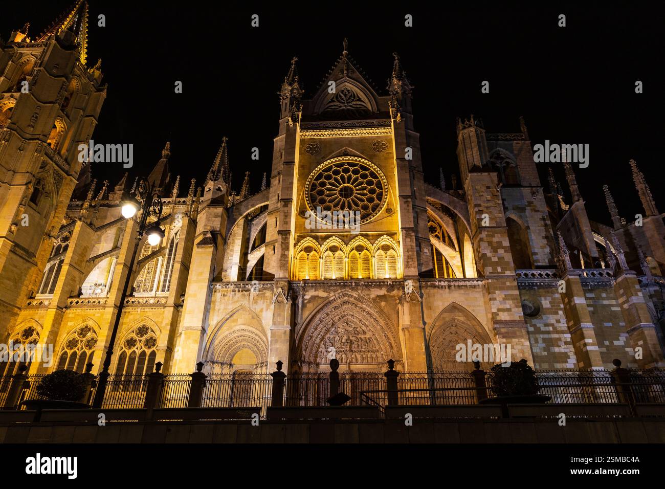 Una vista notturna della porta San Froilán illuminata della cattedrale di León, che mostra i dettagli gotici sotto la luce d'oro. Leon, Castiglia e León, Spagna. Foto Stock
