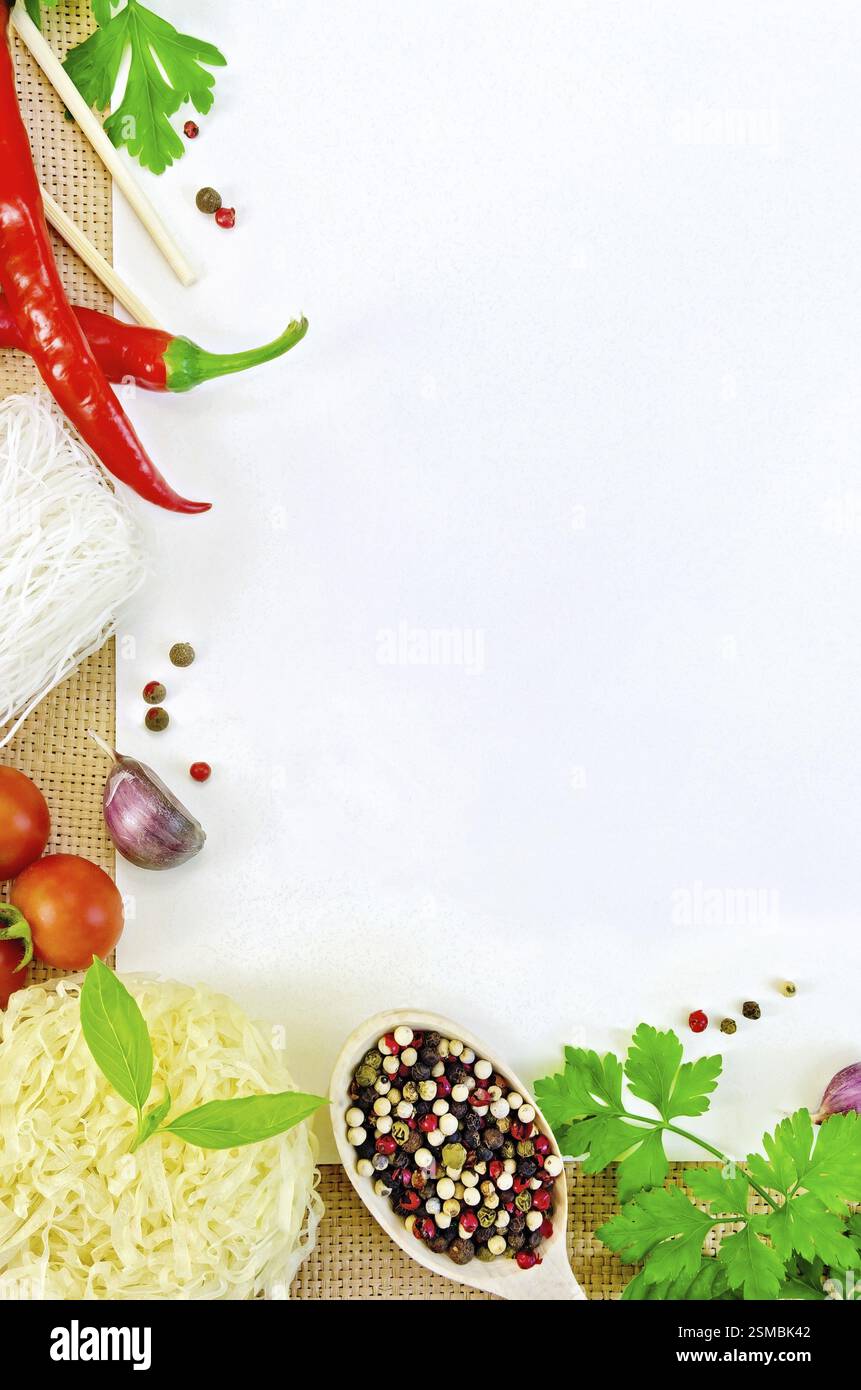 Cornice fatta di spaghetti di riso, pomodori, pepe, prezzemolo, basilico e aglio, libro bianco sul saccheggio Foto Stock