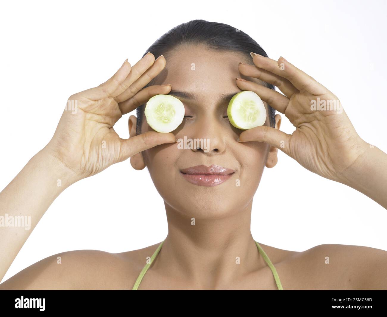 South Asian donna indiana holding e mostrando il cetriolo indossando abito verde signor # 702 Foto Stock