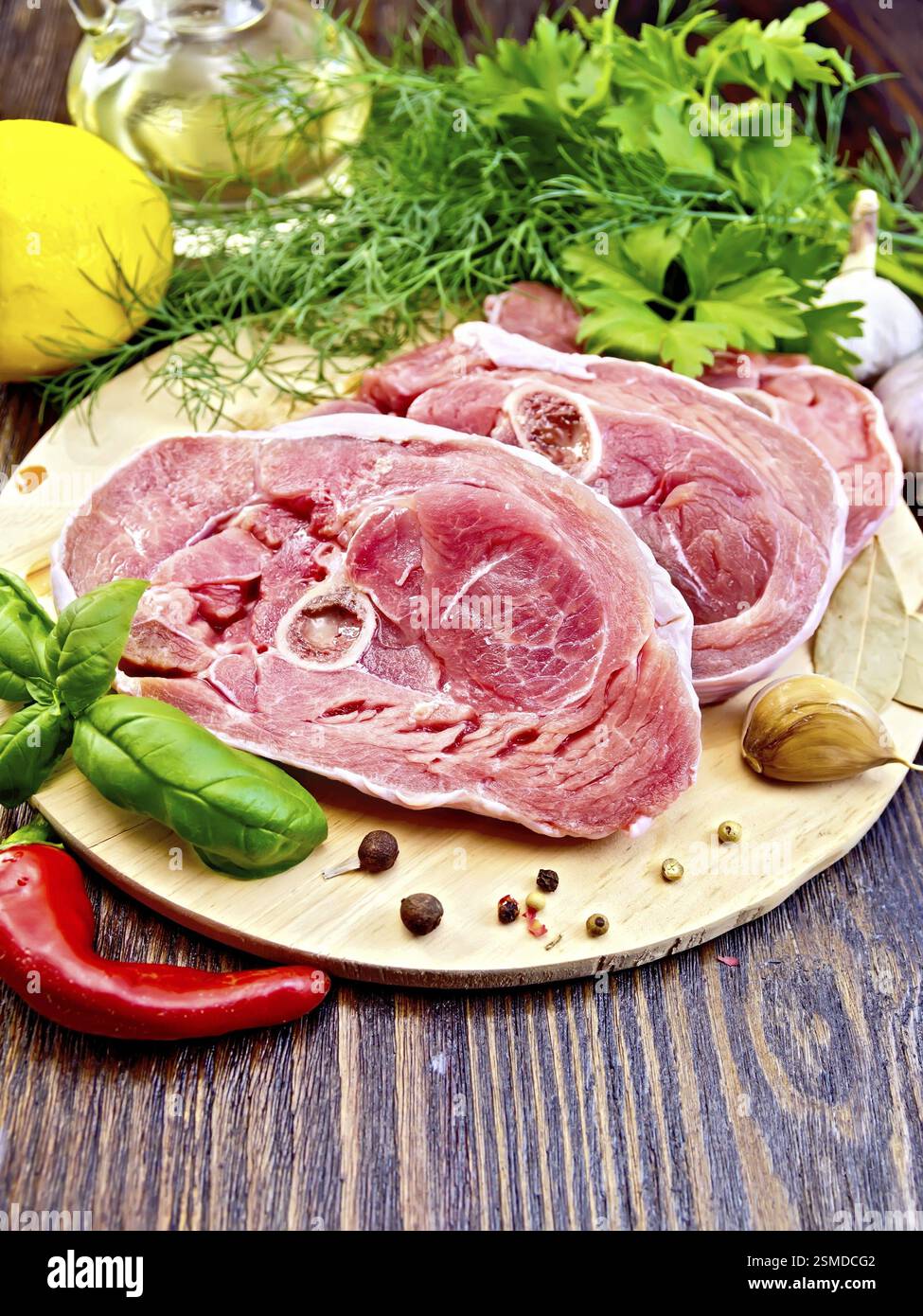 Bistecca carne di tacchino crudo con pepe, basilico, limone e aglio, olio vegetale in un decanter su tavole di legno sfondo Foto Stock