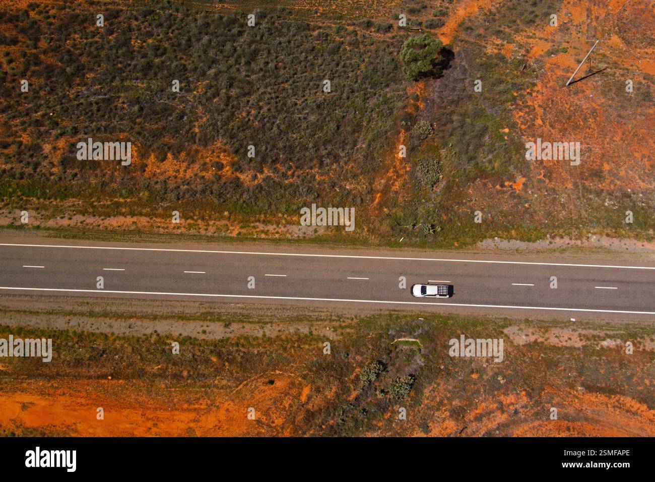 Un pick-up bianco viaggia lungo la Barrier Highway a Little Topar, nuovo Galles del Sud, Australia, attraverso un paesaggio arido sotto la luce del sole. Foto Stock