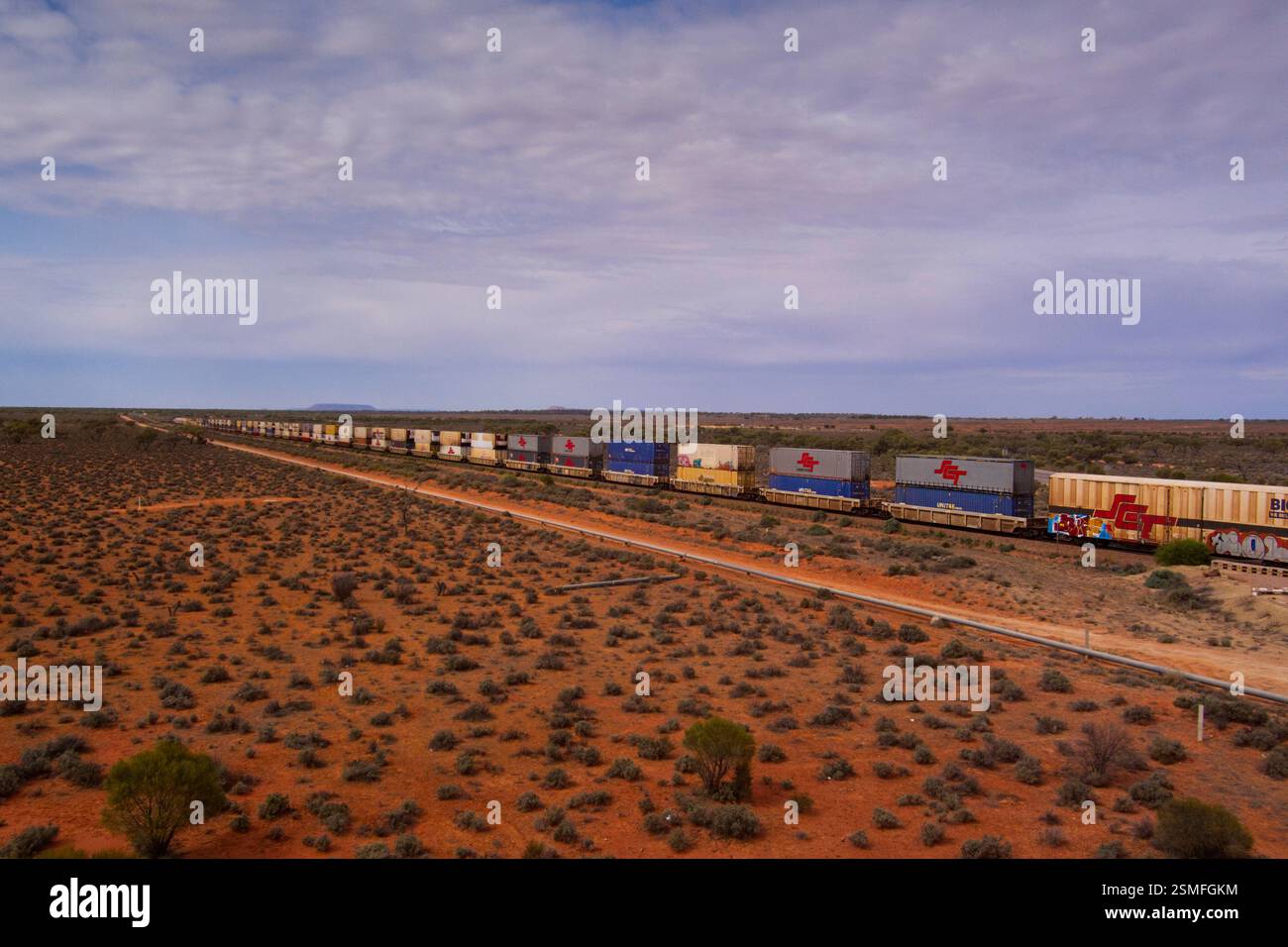 Un treno merci che attraversa l'entroterra dell'Australia meridionale. Il treno è composto da più contenitori impilati uno sopra l'altro. Foto Stock