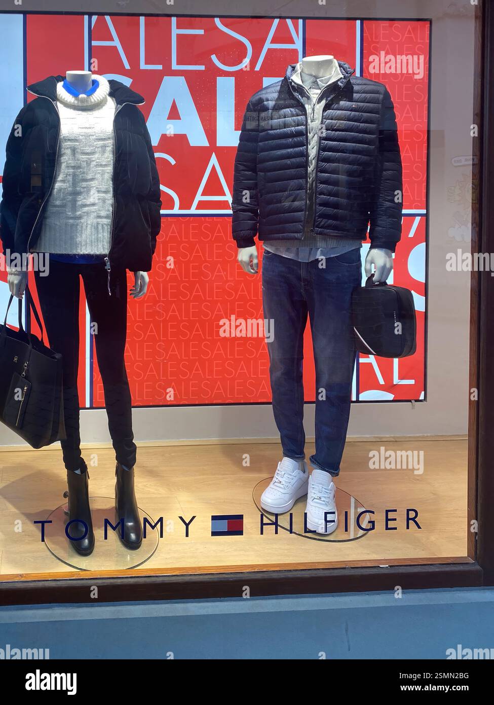 Due manichini che mostrano la moda invernale Tommy Hilfiger durante il periodo di vendita presso il centro commerciale outlet Fidenza Village in Italia Foto Stock