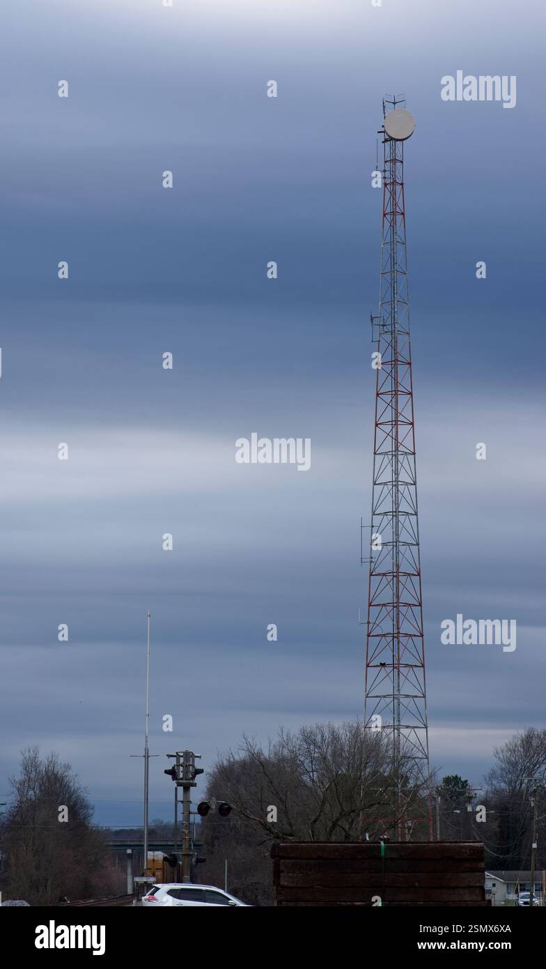 Radio tower con tamburo per microonde contro un cielo blu nuvoloso Foto Stock