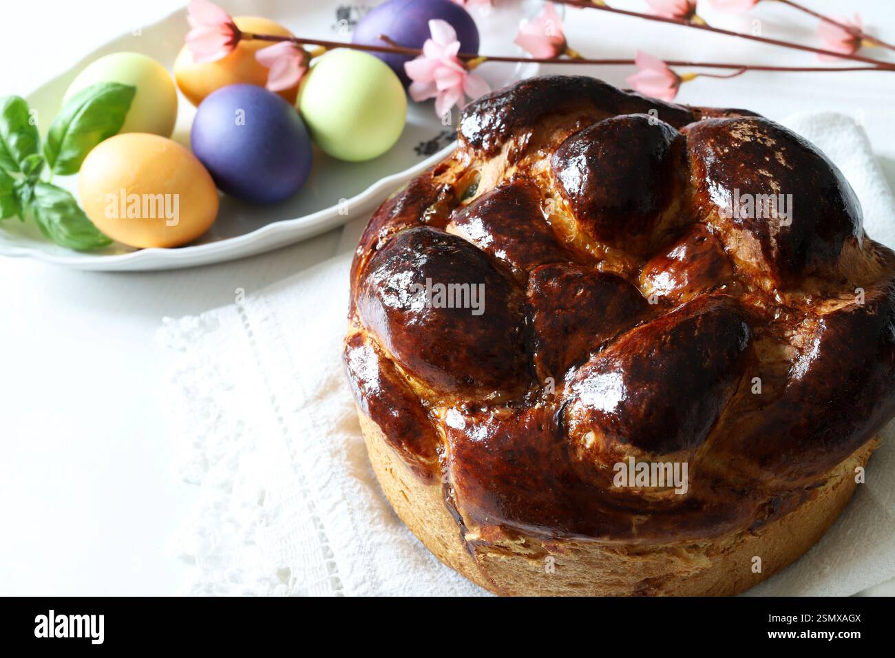 Pane dolce tradizionale e uova colorate per Pasqua sullo sfondo. Concetto di vacanza di Pasqua. Copia spazio. Foto Stock