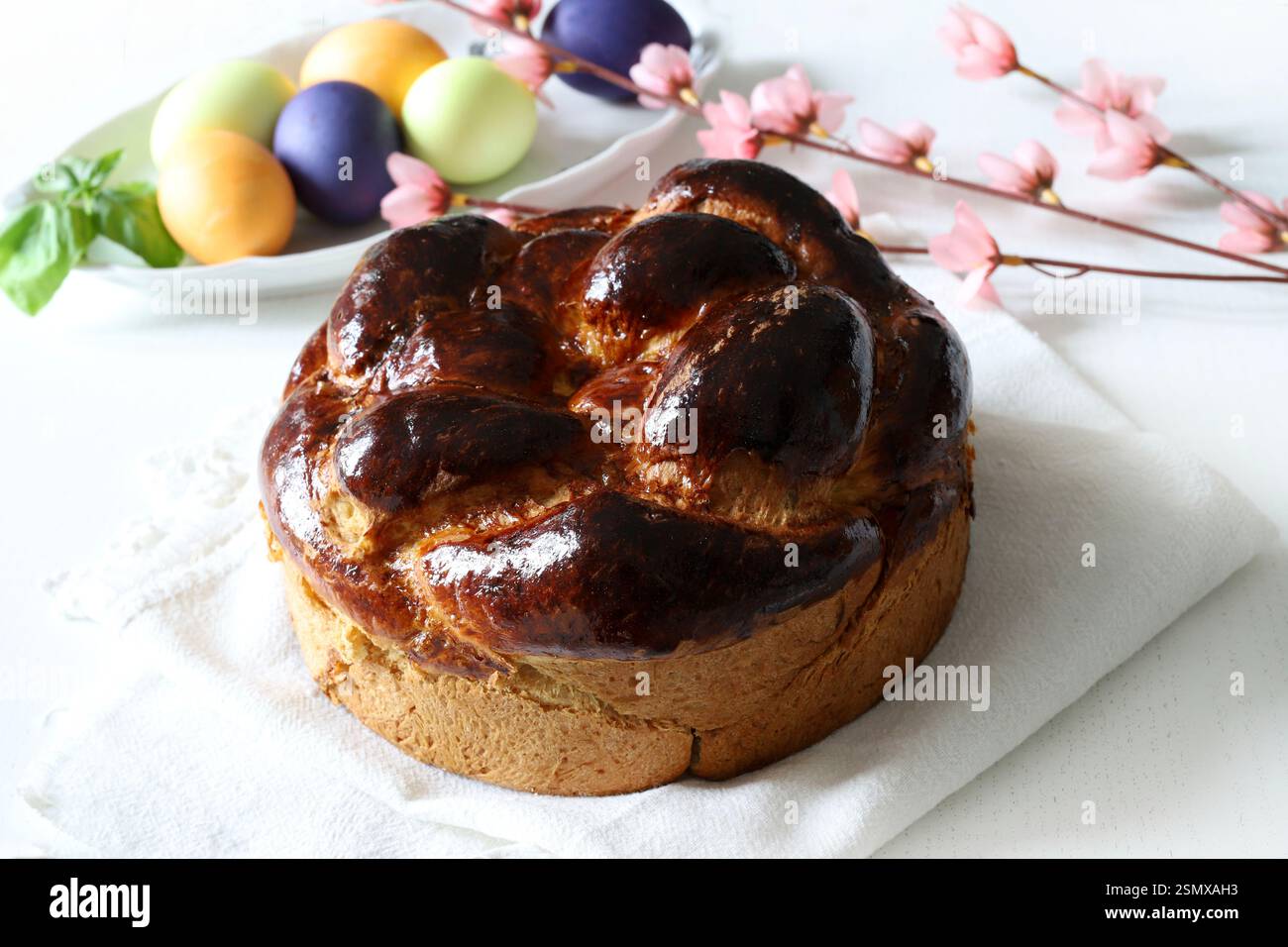 Pane dolce tradizionale e uova colorate per Pasqua sullo sfondo. Concetto di vacanza di Pasqua. Copia spazio. Foto Stock