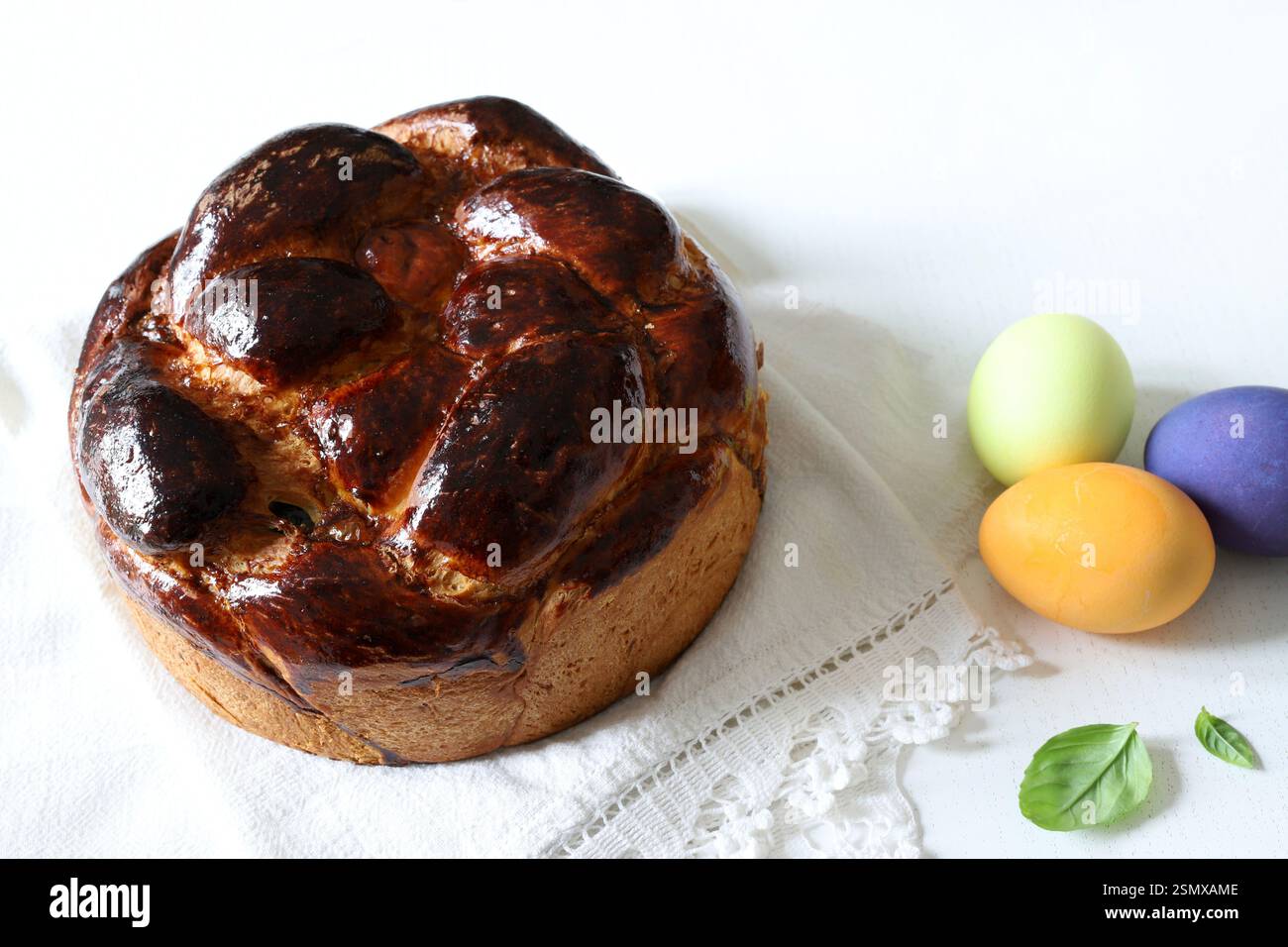 Pane dolce tradizionale e uova colorate per Pasqua sullo sfondo. Concetto di vacanza di Pasqua. Copia spazio. Foto Stock