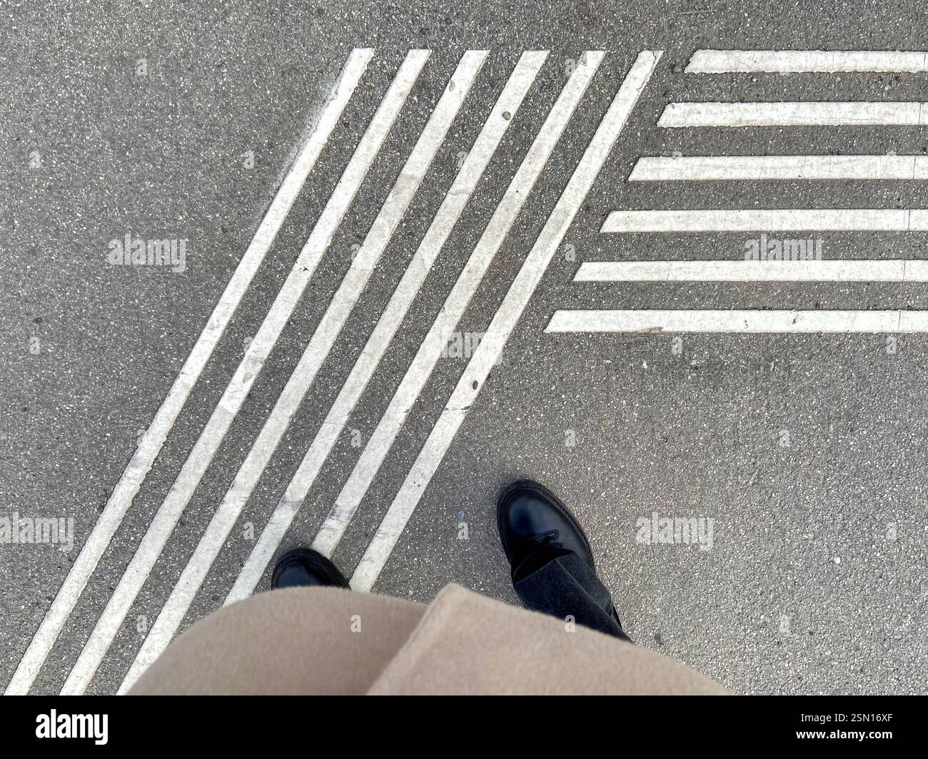 Vista ad angolo alto degli stivali da donna in corrispondenza della segnaletica di attraversamento pedonale - Immagine stock catturata con smartphone