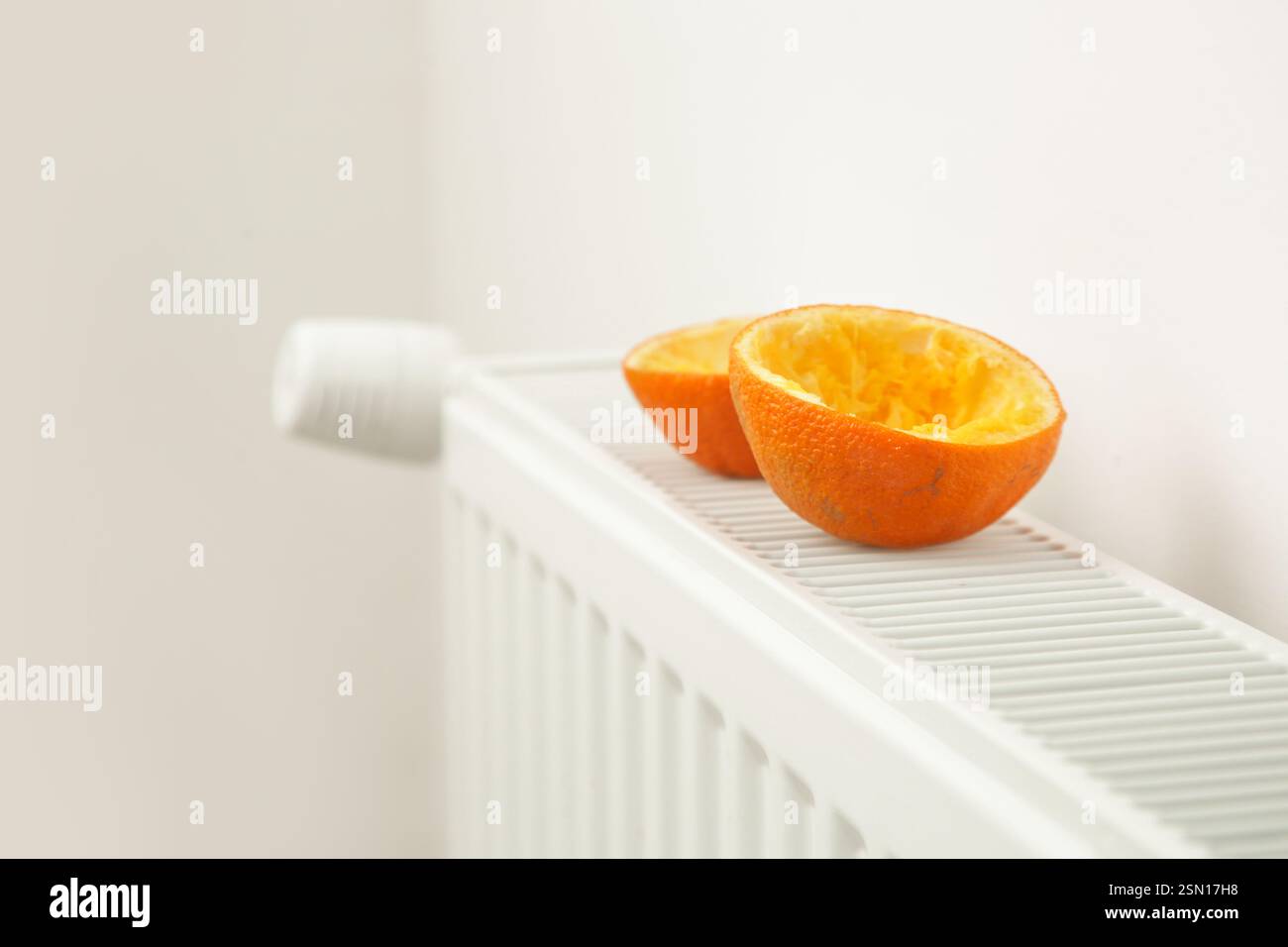 Scorze d'arancia su un radiatore caldo - un deodorante per ambienti naturale ideale che produrrà un piacevole odore dolce che può anche neutralizzare gli odori sgradevoli Foto Stock