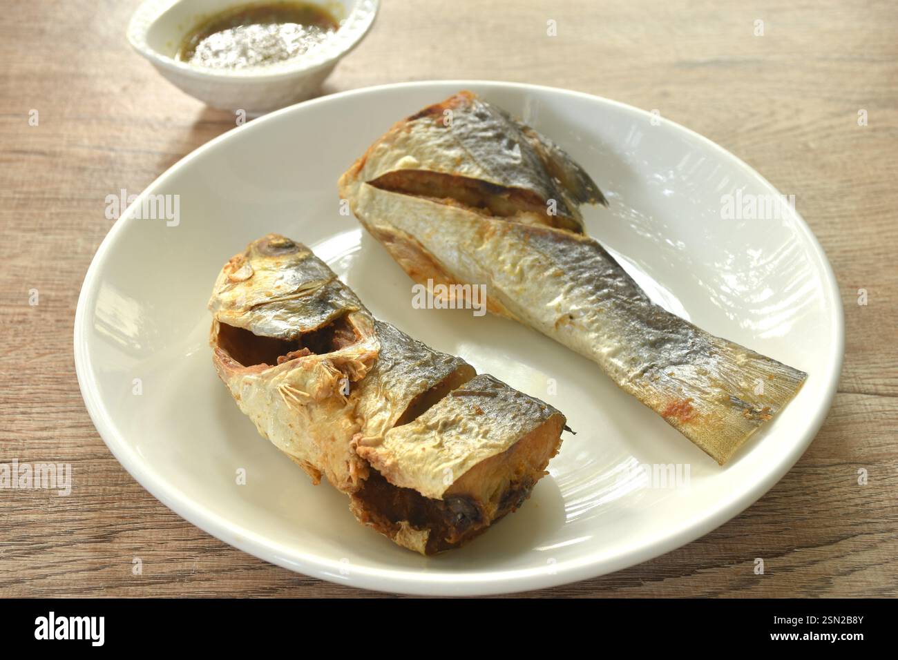 Pesce tigre salato fritto in profondità con salsa di pesce speziata tailandese sul piatto Foto Stock