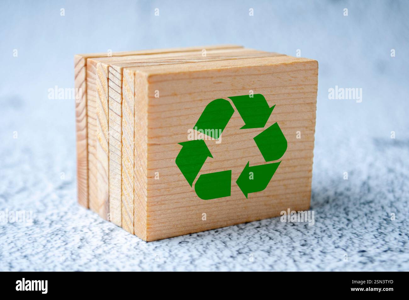 Simbolo di riciclaggio isolato su un quadrato di legno Foto Stock