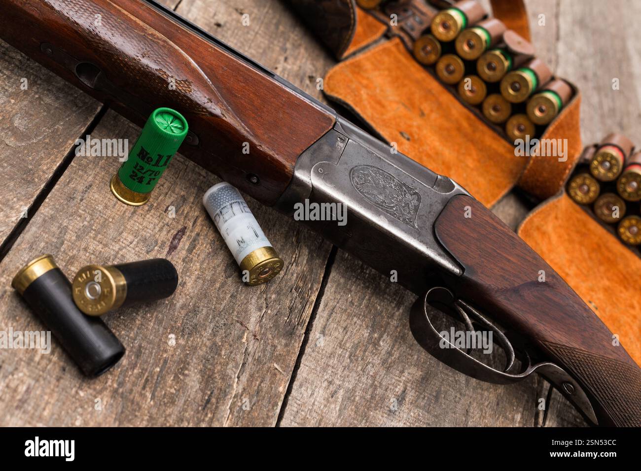 Fucile d'epoca con munizioni montato su un rustico tavolo di legno in ambiente di caccia Foto Stock