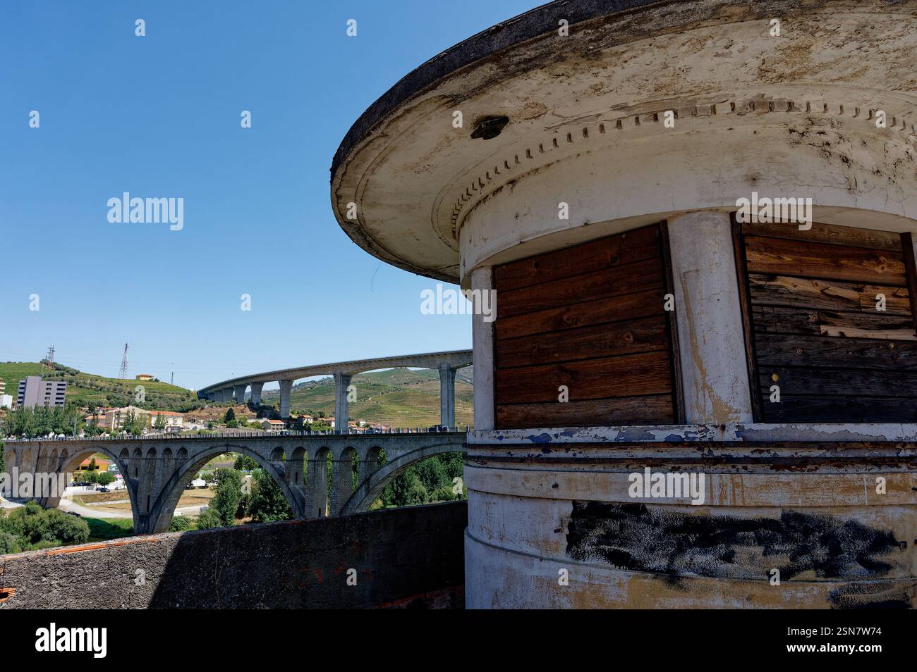 Un punto di osservazione intempestivo con persiane in legno si erge in contrasto con i moderni ponti che attraversano il fiume Douro Foto Stock