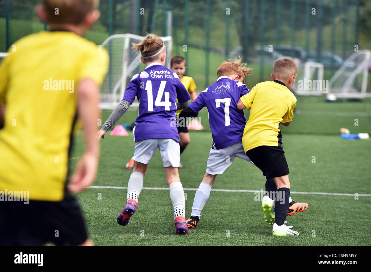I ragazzi giocano a football con una School Holiday Sports Training Academy Foto Stock