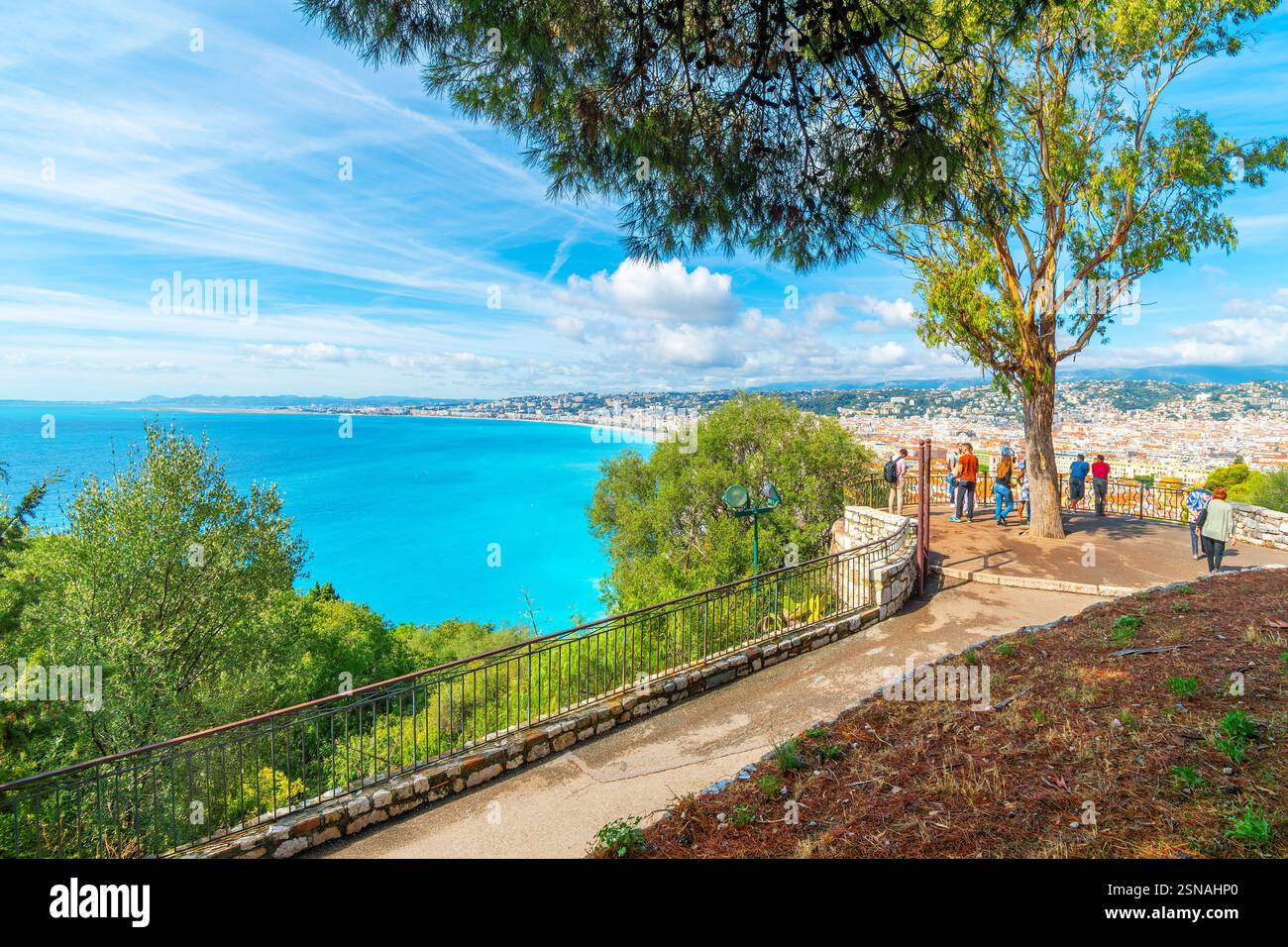 I turisti possono godersi una giornata estiva sulla Collina del Castello che si affaccia sul turchese Mar Mediterraneo, sulla spiaggia di ciottoli e sulla città di Nizza in Francia, sulla Riviera. Foto Stock