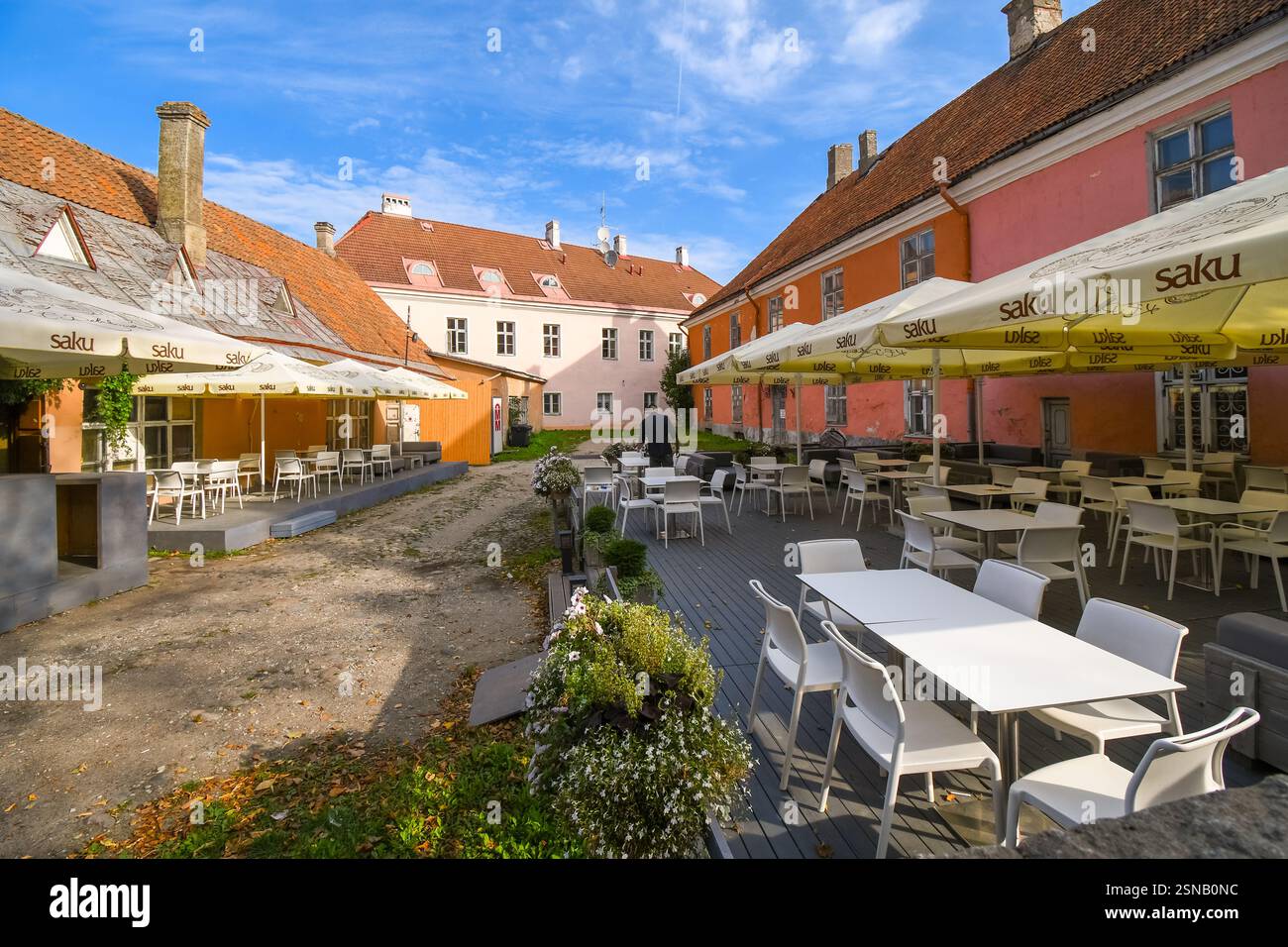 Un lavoratore di servizio predispone un cafe' all'aperto per i clienti nella zona medioevale della collina di Toompea, parte della Città Vecchia di Tallinn, Estonia. Foto Stock