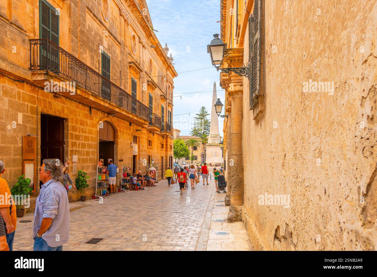 Una stretta strada di negozi e caffetterie che conduce alla piazza Placa la Catedral nella città vecchia medievale di Ciutadella de Menorca. Foto Stock