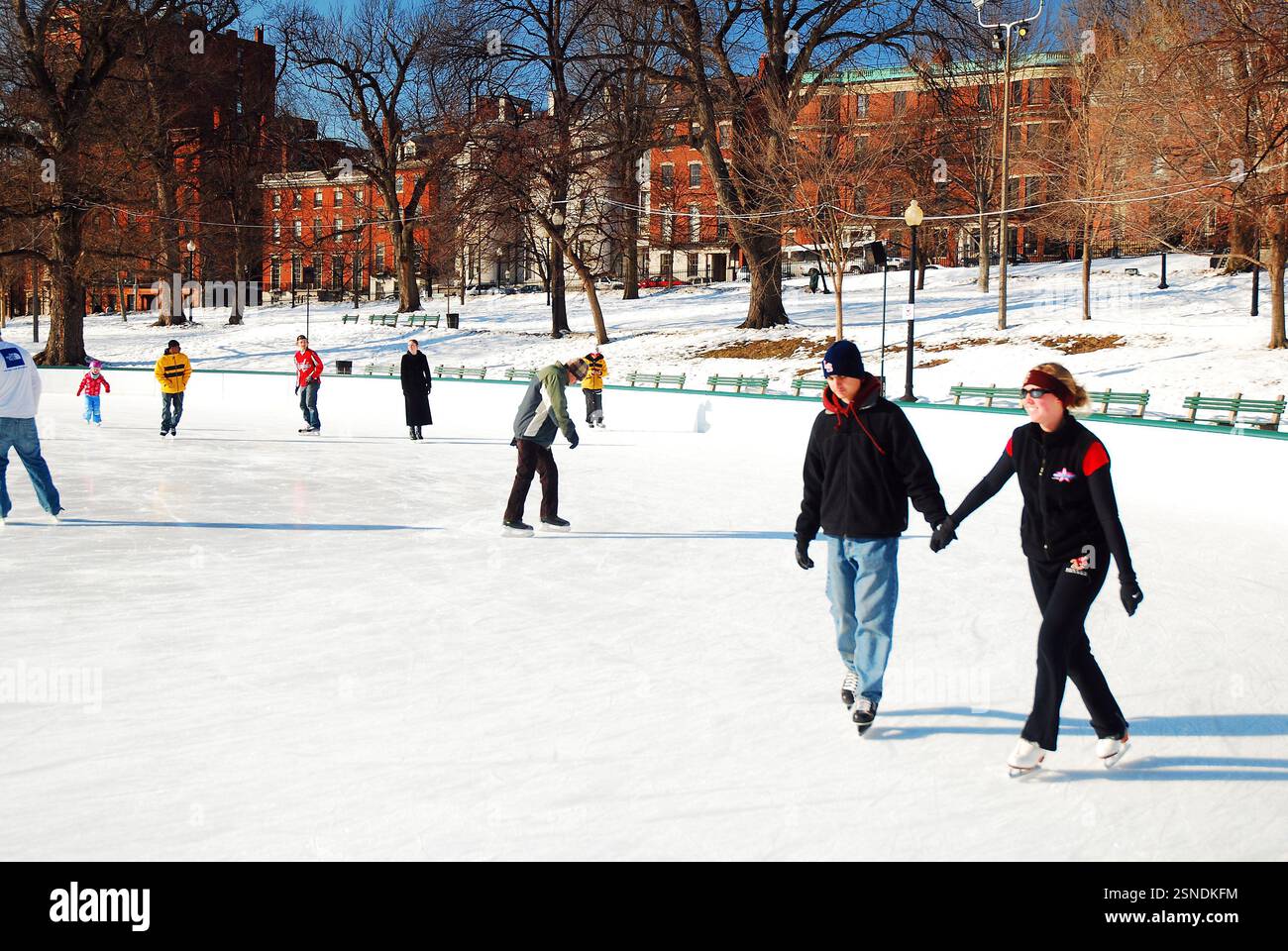 Una coppia si tiene per mano mentre pattina sul ghiaccio sul Frog Pond dei Boston Commons in un appuntamento romantico Foto Stock