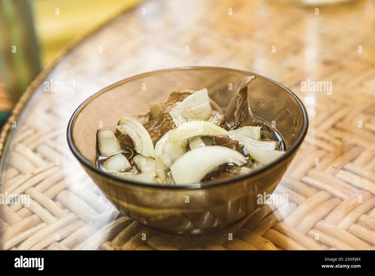 Funghi marinati preparati con cipolle in insalata con olio di oliva, antipasto delizioso prima di cuocere il riso in una padella di acciaio Foto Stock