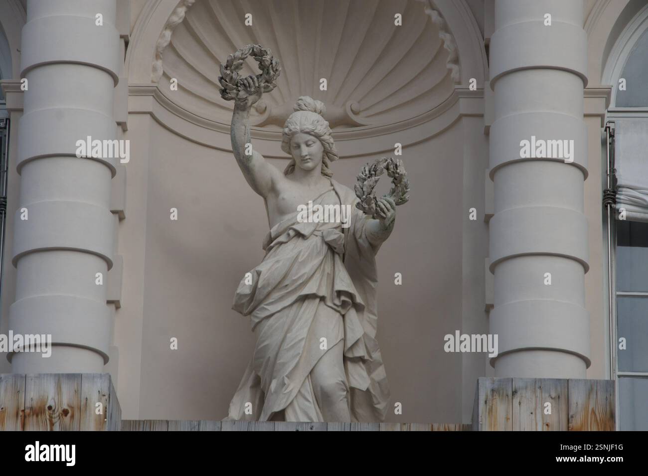 Una statua dorata di una donna alata, probabilmente Nike, la dea greca della vittoria, si trova in Germania, Monaco di Baviera. Tiene una corona in alto sopra la testa, con Foto Stock
