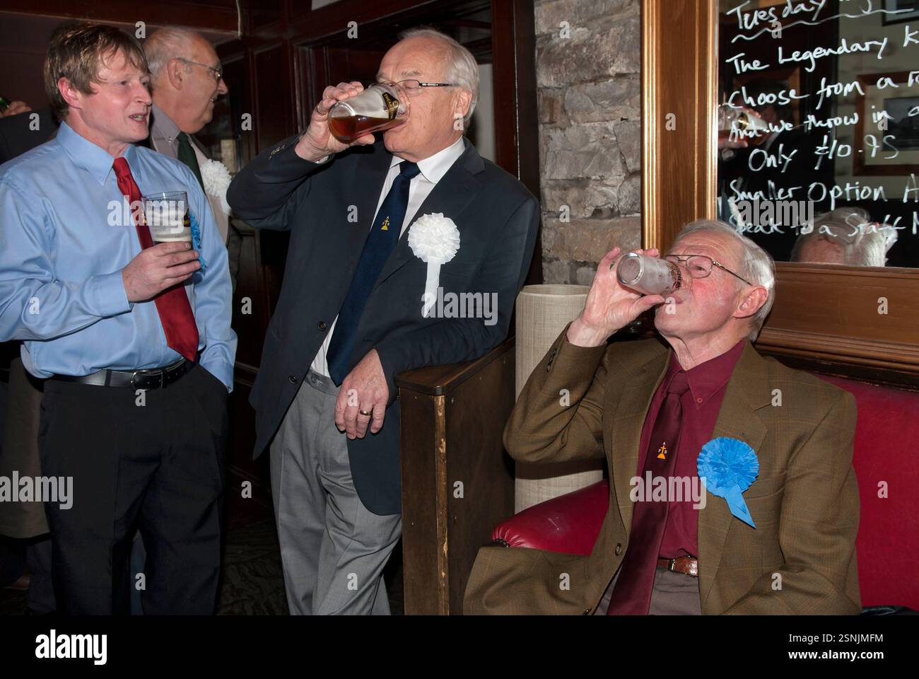 Termina una breve pinta prima della parata annuale alla chiesa di St Oswalds. L'Askrigg Friendly Society è stata fondata nel 1809 ed è la più antica società amichevole del paese. L'iscrizione è aperta agli uomini di Askrigg e dei villaggi e borghi circostanti. Ci sono due gruppi di membri onorari e ordinari. I membri onorari pagano un abbonamento annuale più elevato e indossano rosette bianche e possono richiedere vantaggi fino all'età di 70 anni, mentre i membri ordinari indossano una rosetta blu. Askrigg, North Yorkshire, Inghilterra 5 giugno 2014 2010s UK HOMER SYKES Foto Stock