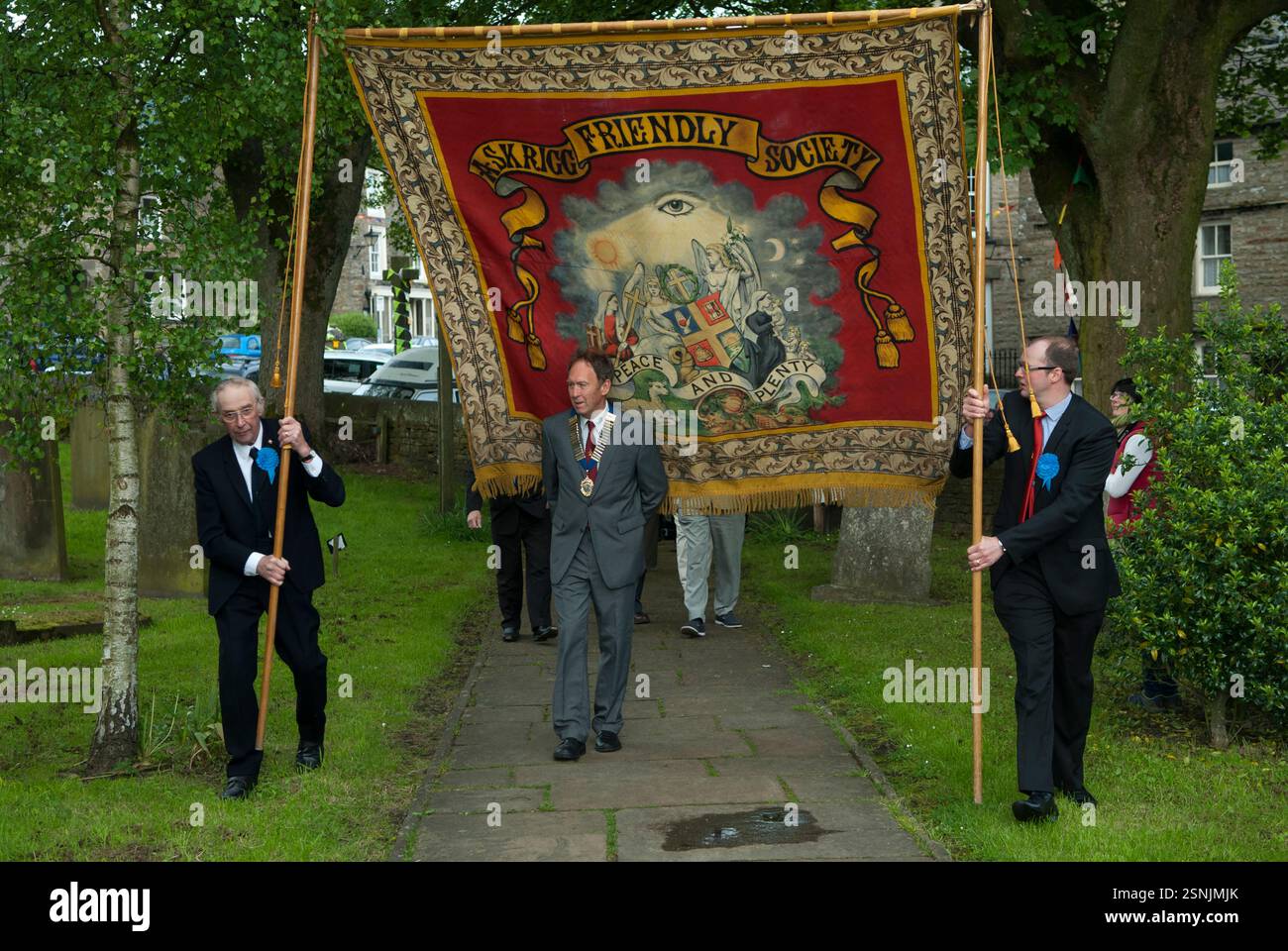 Yorkshire England, uomini locali, membri della Askrigg Equitable Benevolent and Friendly Society frequentano la chiesa di St Oswalds camminando dietro il loro vessillo per il servizio sociale del Ringraziamento. Askrigg, North Yorkshire, Inghilterra 5 giugno 2014 2010s UK HOMER SYKES Foto Stock