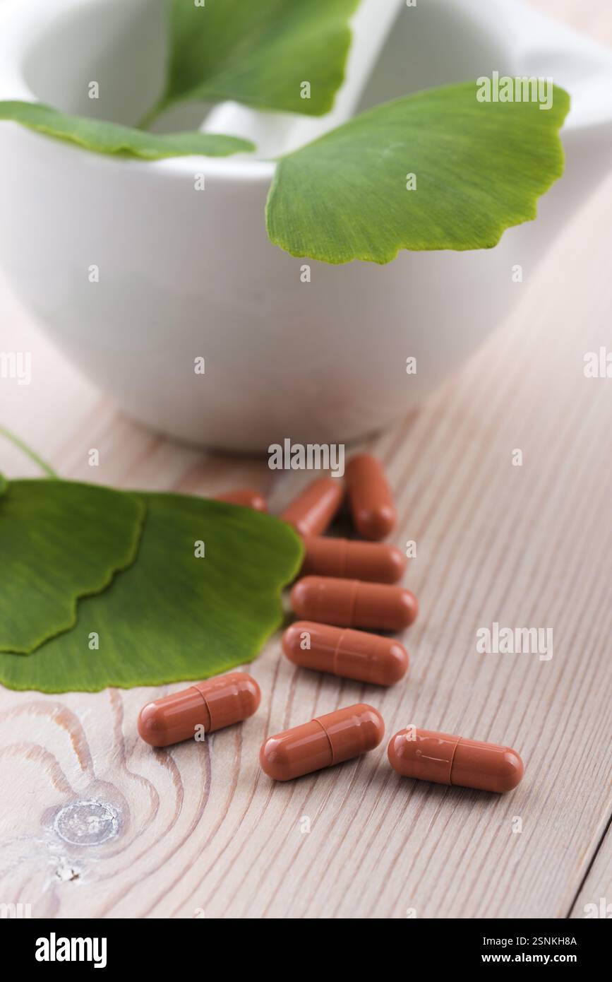 Foglie di Ginkgo biloba in mortaio e pillole, lodz, polonia Foto Stock