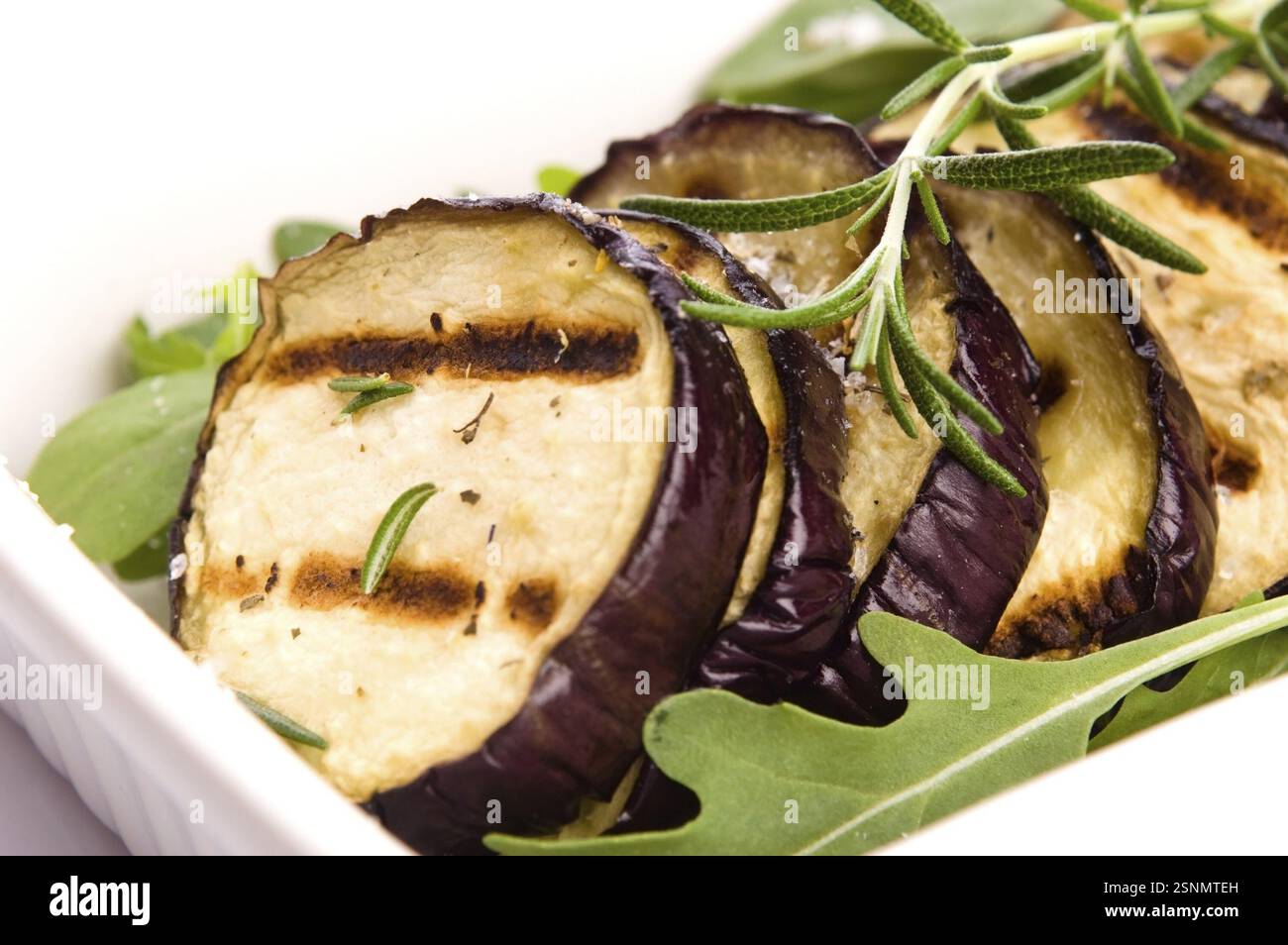 Fette di melanzana grigliate su un piatto con rosmarino fresco, lodz, polonia Foto Stock
