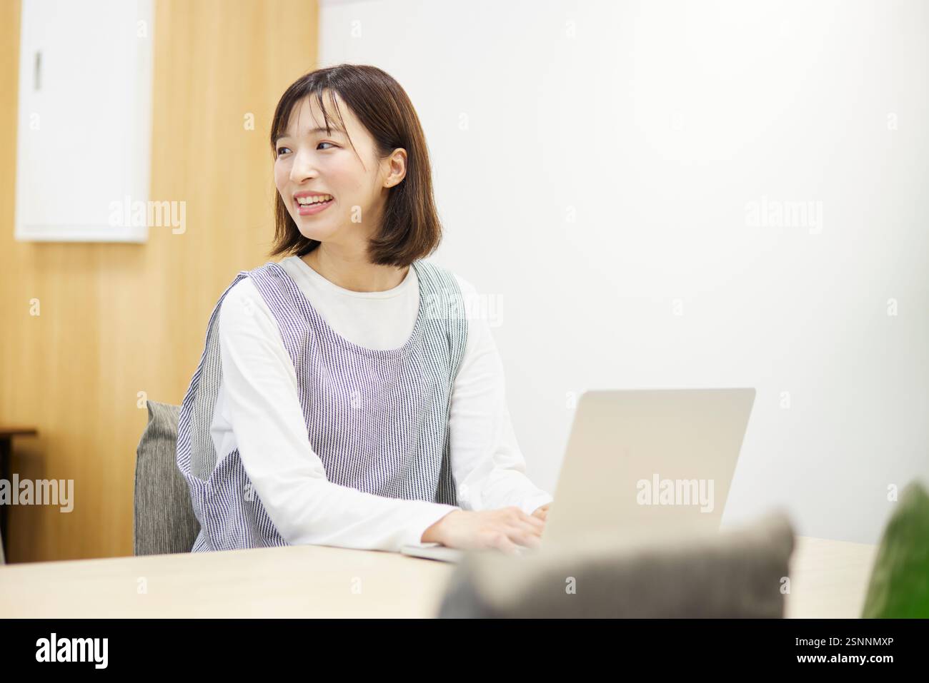 Lavoratrice di assistenza all'infanzia al lavoro che utilizza un notebook in una scuola materna Foto Stock