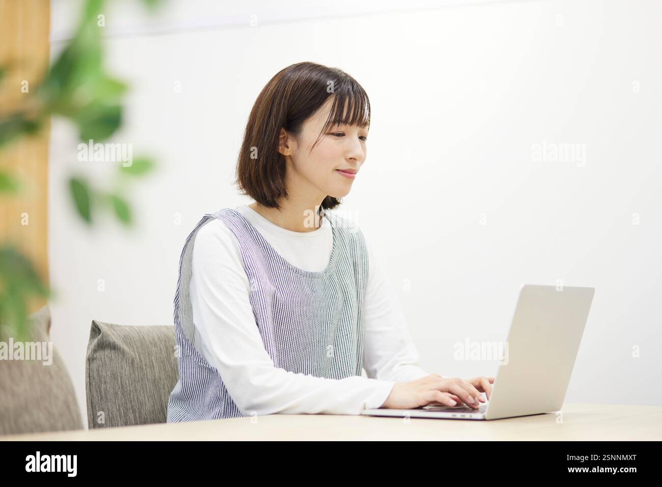 Lavoratrice di assistenza all'infanzia che lavora con un notebook in una scuola materna Foto Stock