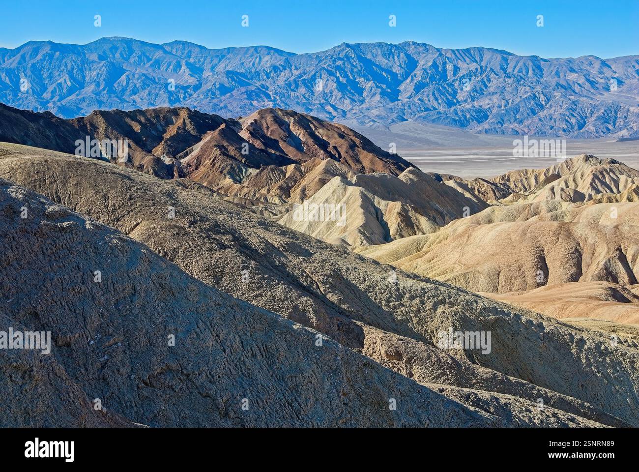 Pendii multicolori a Zabriskie Point con le lontane montagne Panamint Foto Stock
