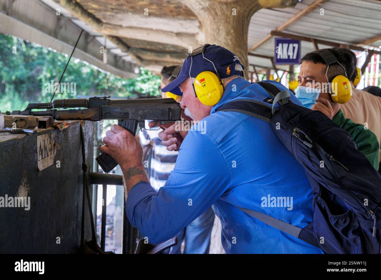 I turisti sparano con una mitragliatrice AK47 al National Defence Sports Shooting Range presso Cu chi Tunnels, ho chi Minh - Saigon, Vietnam, Foto Stock