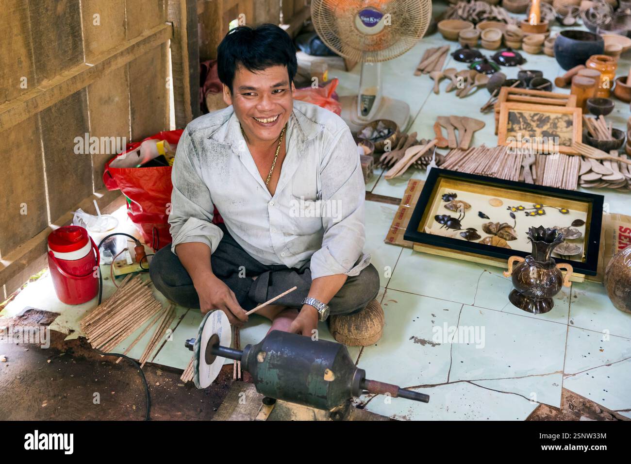 Un artigiano che lavora con un tornio in un laboratorio tradizionale circondato da oggetti artigianali in Vietnam, Quoi Son, Vietnam, lunedì 11 novembre, 2024. Foto Stock