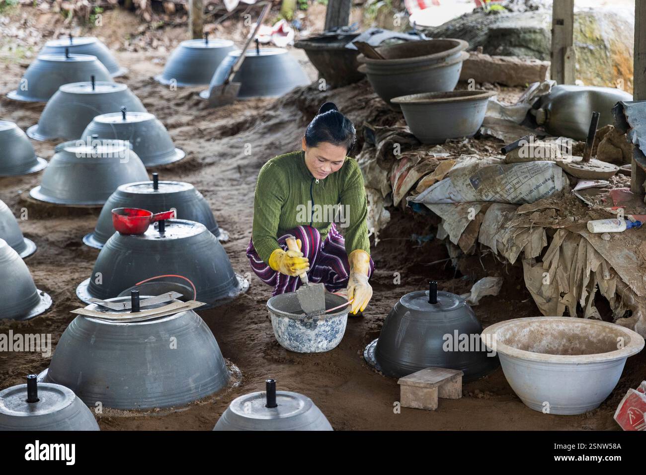Una donna che produce vasi di fioriera di argilla in un laboratorio rurale a Cho Lach, Vietnam, lunedì 11 novembre 2024. Foto: David Rowland / One-Image.com Foto Stock