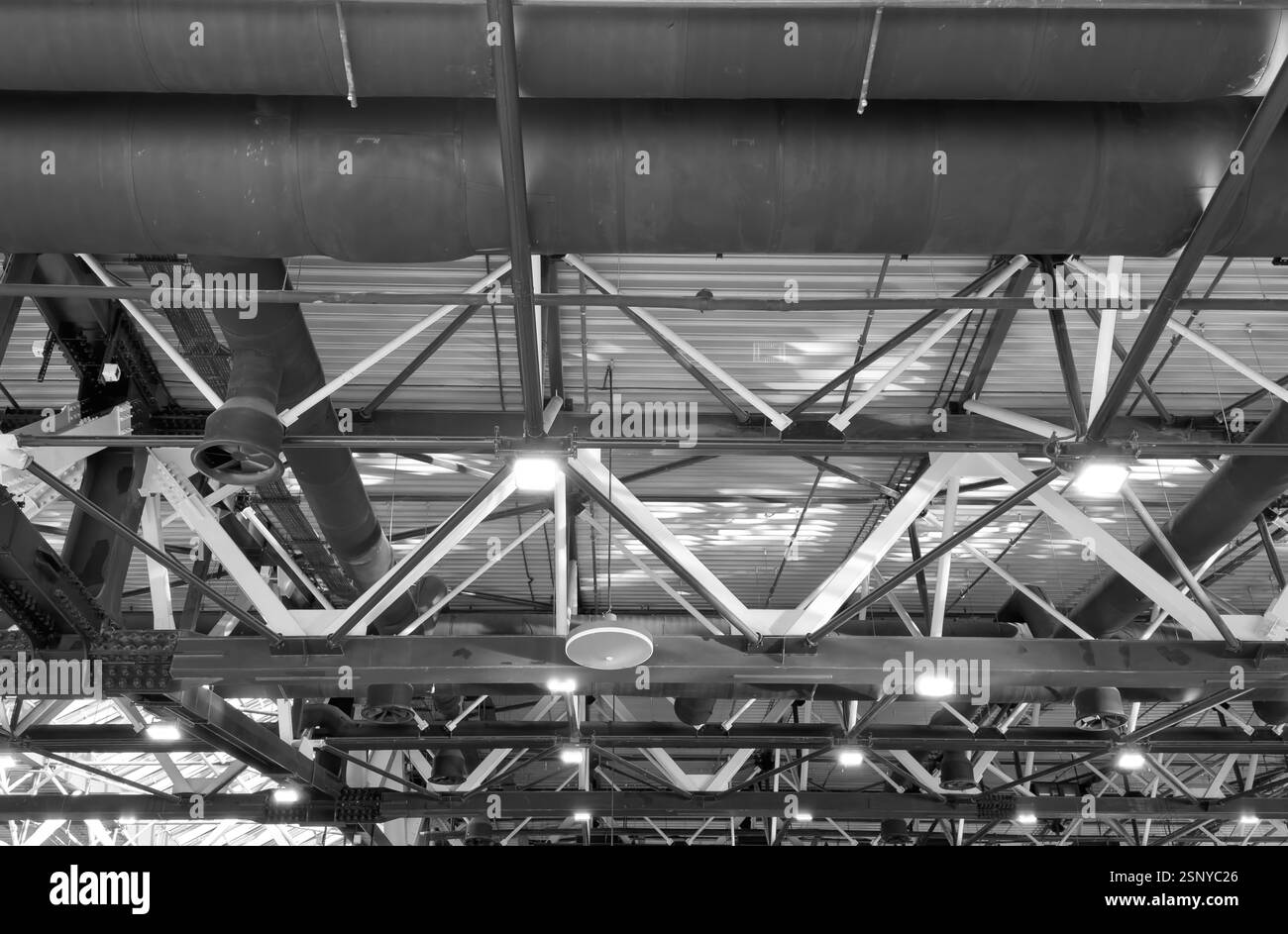 Luci e sistema di ventilazione a lunga linea sul soffitto dell'edificio industriale. Sala esposizioni. Costruzione di una fabbrica di soffitti. Foto Stock