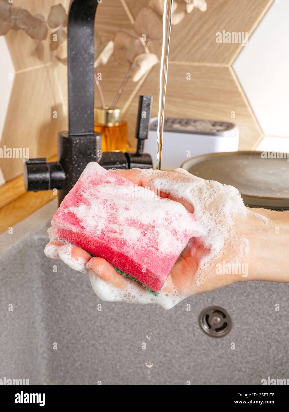 spugne per lavare piatti sotto acqua corrente in schiuma Foto Stock