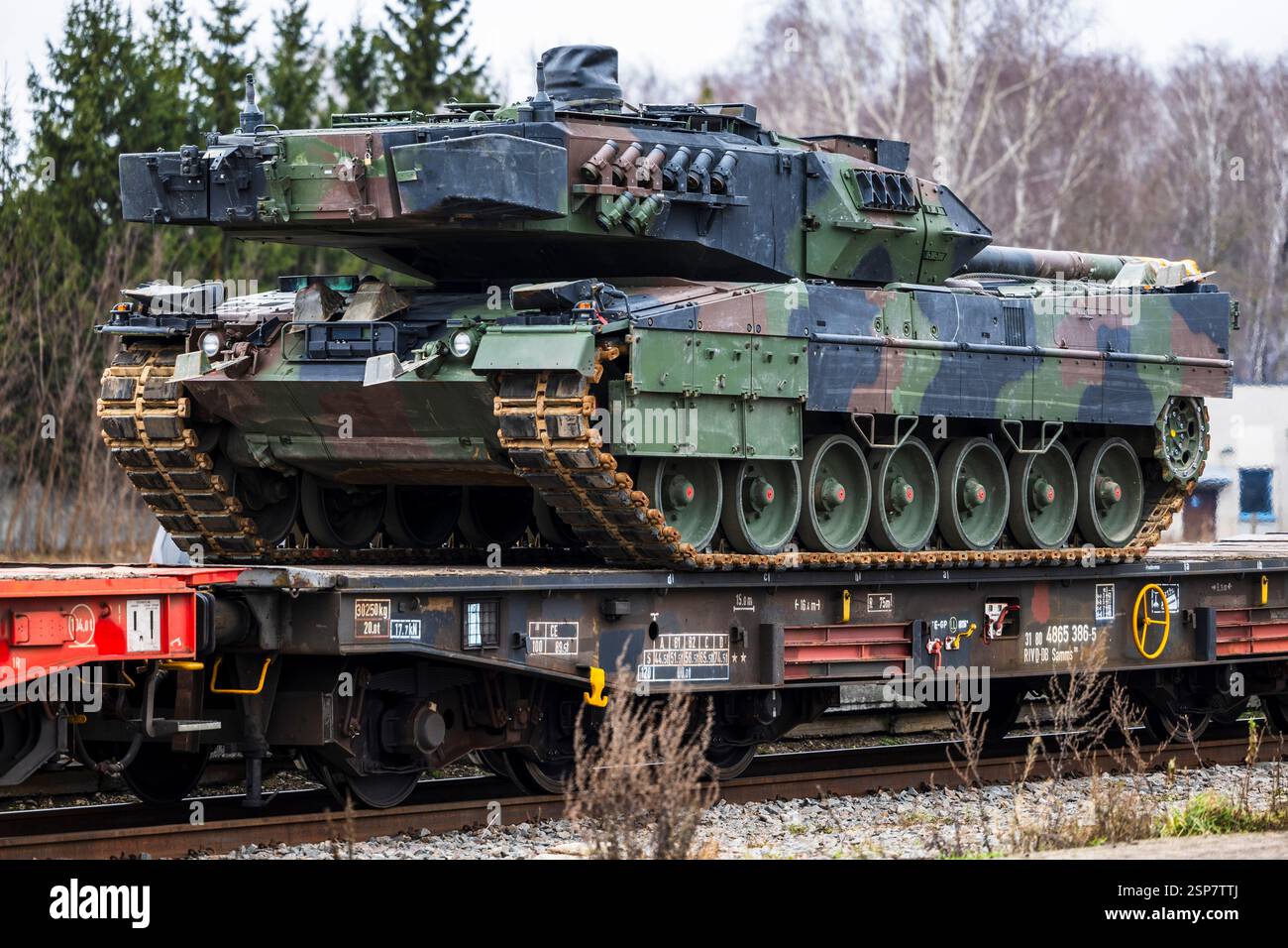 Un convoglio di carri armati da battaglia tedeschi Leopard 2 caricati su vagoni ferroviari a pianale per il trasporto militare, evidenziando lo spiegamento strategico e logistico Foto Stock