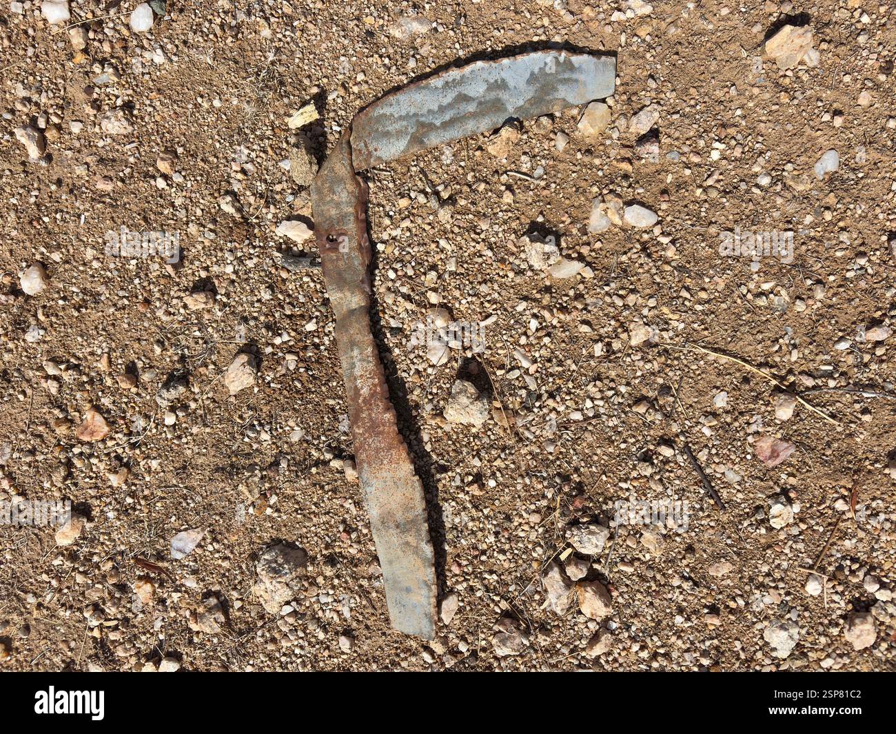 Oggetto metallico arrugginito adagiato su terreni rocciosi desertici alla luce del sole Foto Stock