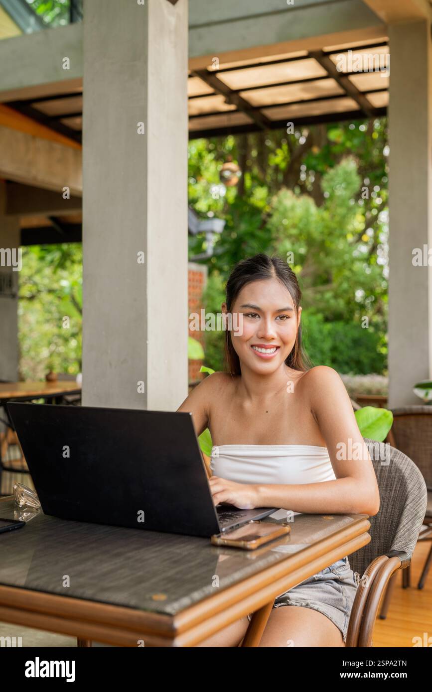 Giovane donna che lavora su un notebook nel concetto di ristorante Foto Stock