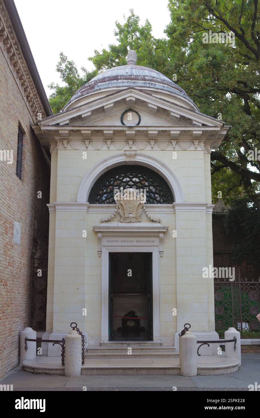 Un mausoleo indipendente in pietra biancastra con tetto a cupola, ingresso ad arco ed elementi decorativi. E' situato vicino ad un muro di mattoni, in parte S. Foto Stock