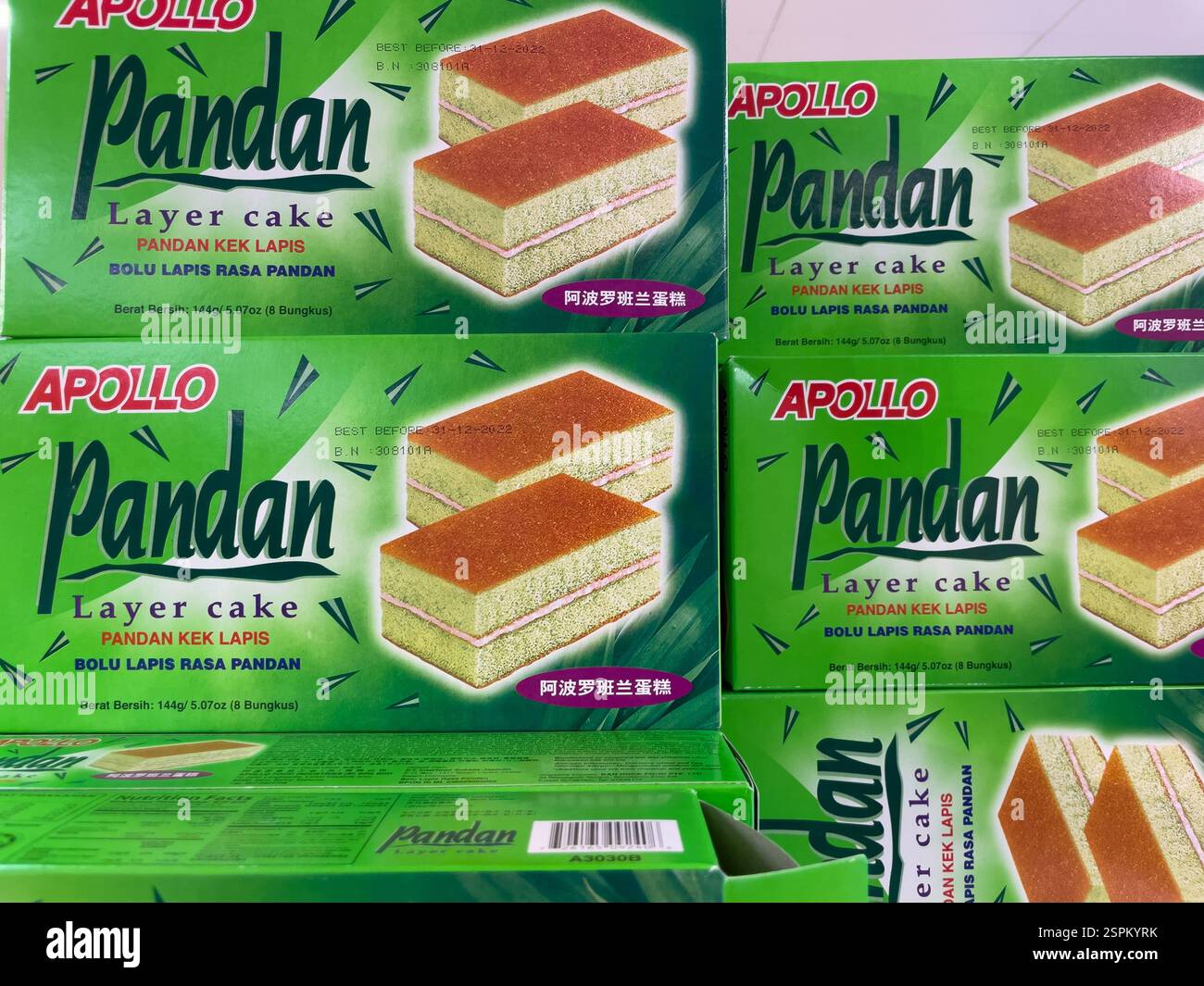 Sono impilate più scatole di torta a strati Pandan Apollo. Ogni scatola presenta una confezione verde e bianca che mostra un'immagine della torta e del testo in mulo Foto Stock