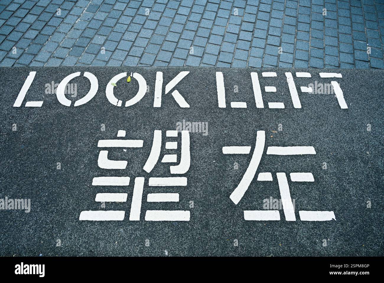Guarda a sinistra, Warnhinweis auf dem Asphalt, Hong Kong, Volksrepublik Cina Foto Stock