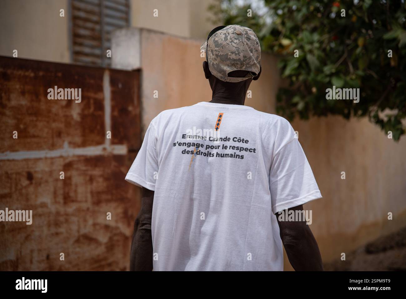 Foth, Senegal. 22 dicembre 2024. Abou Ka che ha lavorato per 14 anni come guardia di sicurezza alla ERAMET GCOI e la cui maglietta indossa ancora, qui all'ingresso della sua casa nel villaggio di reinsediamento di Foth, il 22 dicembre 2024. Oggi, Abou Ka svolge piccoli compiti quotidiani come bruciare spazzatura nel villaggio per 1000 franchi CFA al giorno. (1,5 euro) - 22/12/2024 - Senegal/Thies/Foth - Nicolas Remene/le Pictorium credito: LE PICTORIUM/Alamy Live News Foto Stock