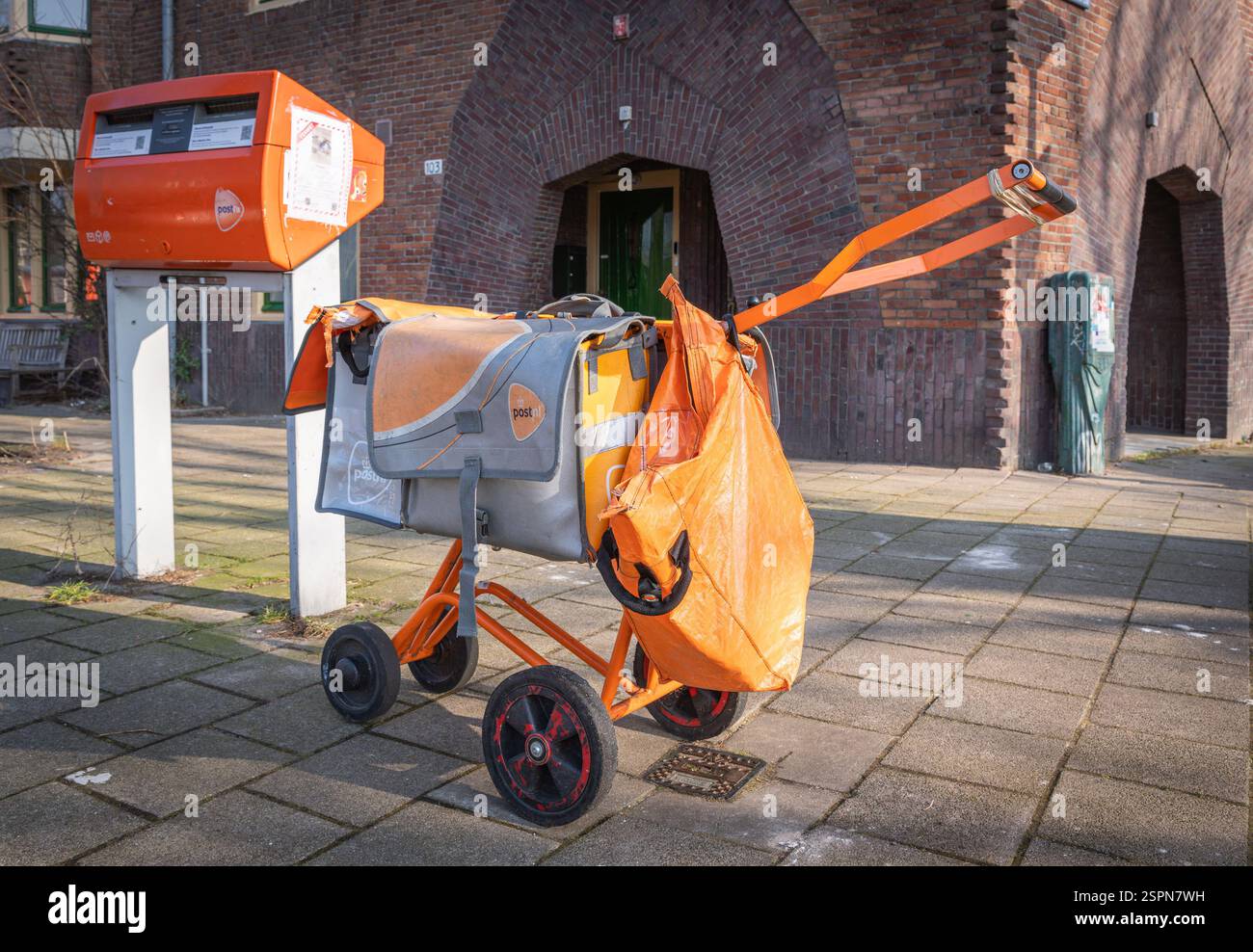 Amsterdam, Paesi Bassi, 14.02.2025, carrello di consegna PostNL e borse arancioni con posta in strada, posta olandese, pacchi e società di e-commerce Foto Stock