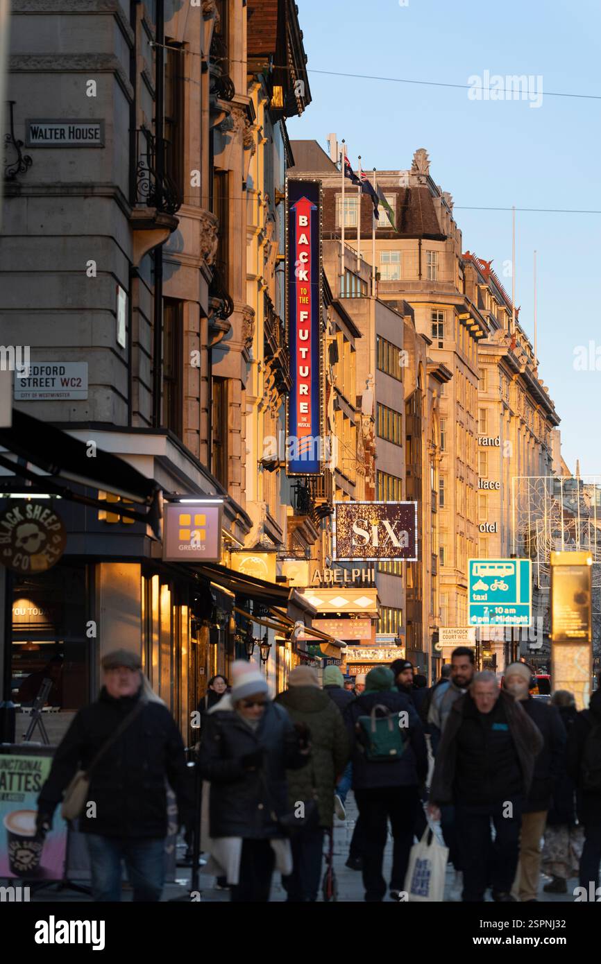 Pedoni in Bedford Street WC2, Londra, vicino all'Adelphi Theatre, con le indicazioni per "ritorno al futuro" e "sei" musical. Foto Stock